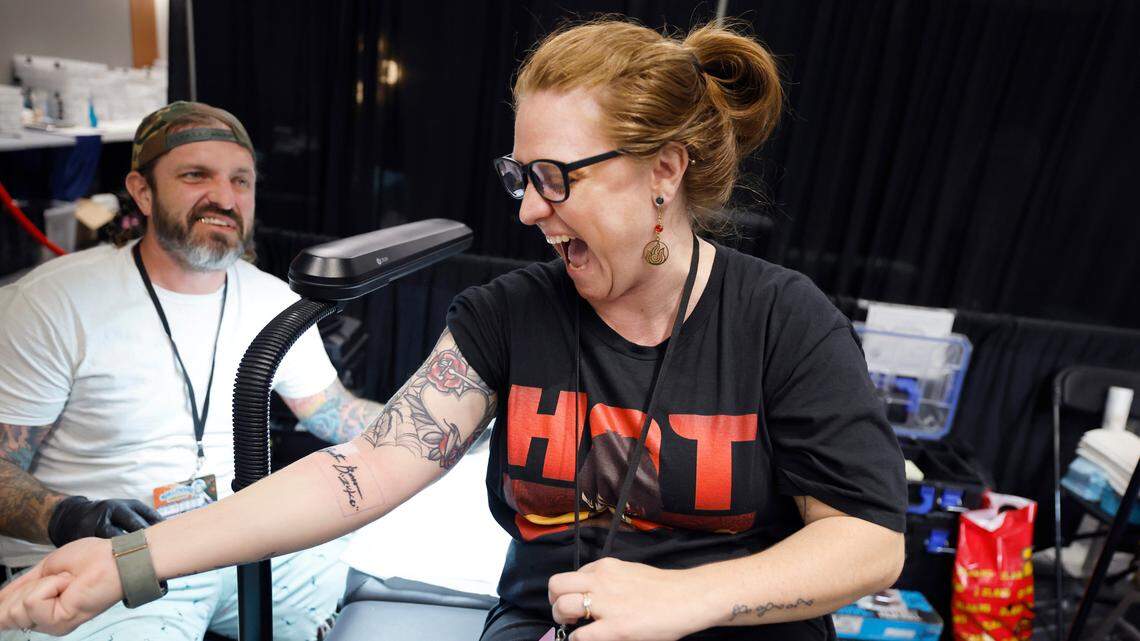 Danielle Christensen of Wendell gets her first look at the tattoo of Dante Bosco on her arm at GalaxyCon in Raleigh, N.C., Saturday, July 27, 2024. The tattoo is part of GalaxyCon’s celebrity tattoo experience where you get a body part autographed by talent and then right afterward get the signature tattooed by River City Tattoo Company. Christensen’s tattoo artist Adam Phillips is to the left.