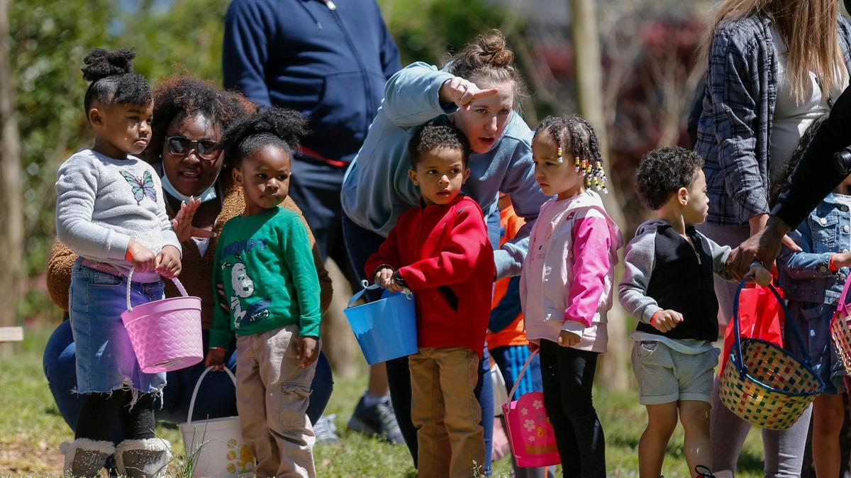 Moms give children tips before the start of an Easter egg hunt in 2021.