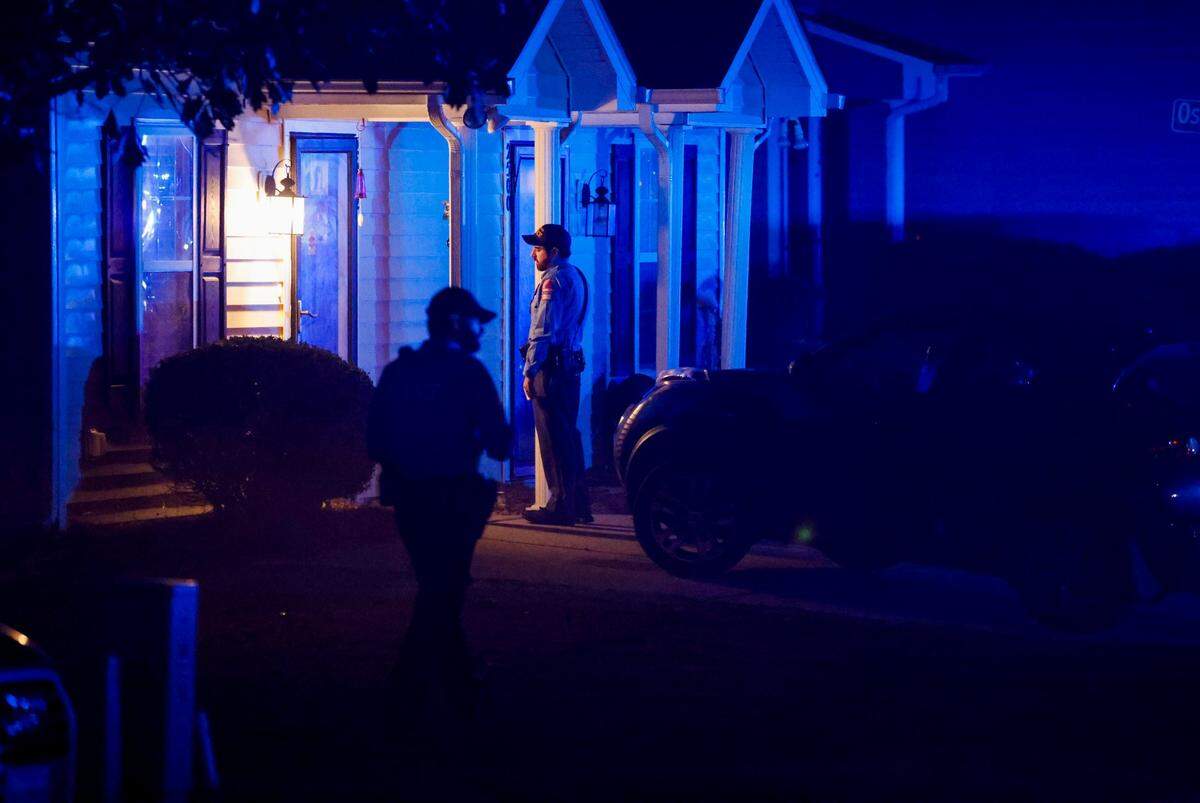 Raleigh police officers walk door to door checking on residents in the Hedingham neighborhood and Neuse River Trail area in Raleigh after 5 people were shot and killed Thursday, Oct. 13, 2022.