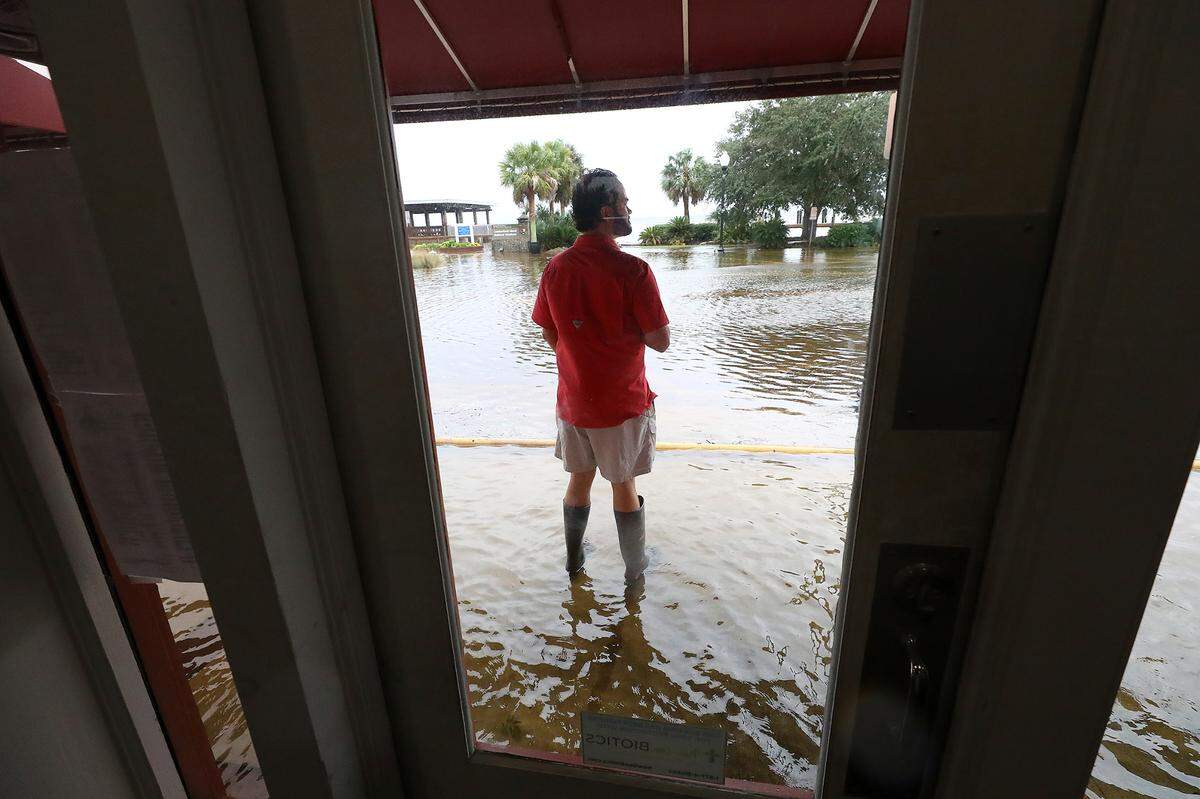 Bert Guy, concerned co-owner of the historic Riverview Hotel, watches while standing in rising flood waters from Tropical Storm Ian begin surrounding the hotel built in 1916 during high tide on Thursday, Sept. 29, 2022, in downtown St. Mary’s, Ga.
