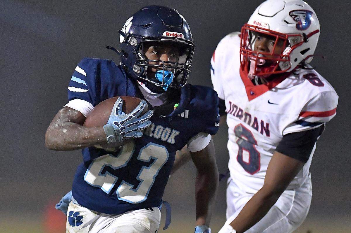 Millbrook running back Santonis Wright (23) runs for yardage against Jordan linebacker Ryan Smith (6) during the second half. The Millbrook Wildcats and the Jordan Falcons met in the third round of the NCHSAA 8A football playoffs in Raleigh, N.C. on November 21, 2025. 
