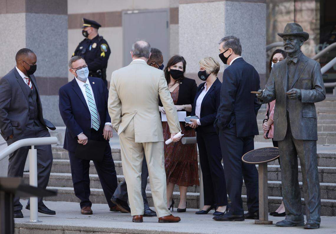 North Carolina Democratic Gov. Roy Coope, right, and lawmakers gather Wednesday morning, March 10, 2021, in advance of a press conference to announce leaders of the Republican-led state legislature and the governor have reached an agreement to reopen the stateÕs K-12 public schools to full-time daily instruction.