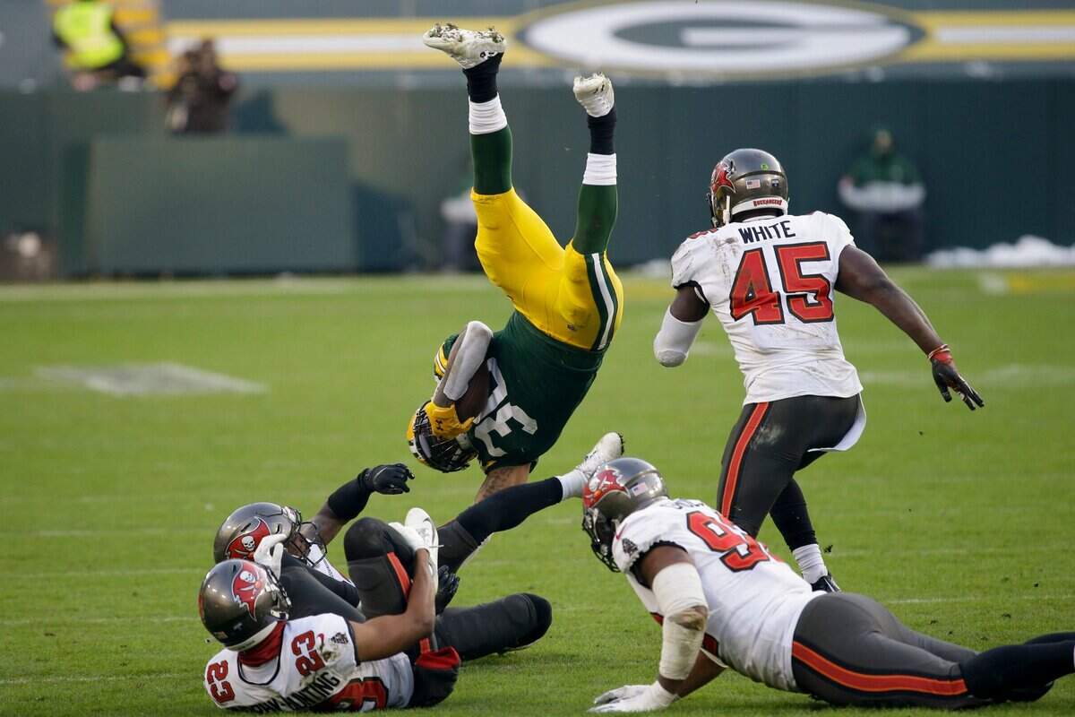 Green Bay Packers’ Jamaal Williams (30) is upended by the Tampa Bay Buccaneers during the second half of the NFC championship NFL football game in Green Bay, Wis., Sunday, Jan. 24, 2021.