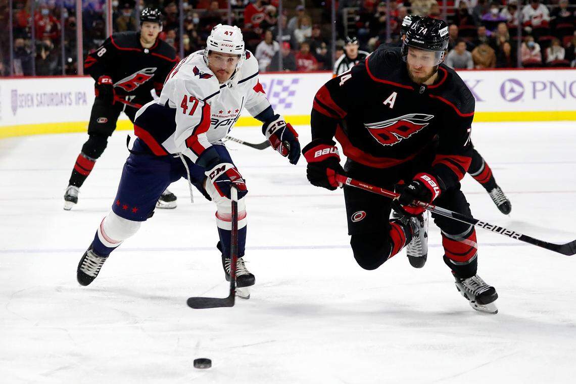 Carolina Hurricanes’ Jaccob Slavin (74) and Washington Capitals’ Beck Malenstyn (47) chase the puck during the first period of an NHL hockey game in Raleigh, N.C., Sunday, Nov. 28, 2021. (AP Photo/Karl B DeBlaker)