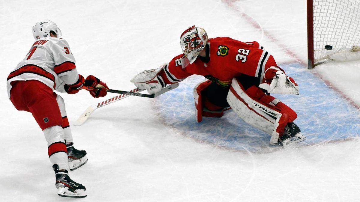 Carolina Hurricanes right wing Andrei Svechnikov (37) shoots a shootout winning goal during overtime of an NHL hockey against Chicago Blackhawks goaltender Kevin Lankinen (32), Tuesday, Feb. 2, 2021, in Chicago. (AP Photo/Matt Marton)