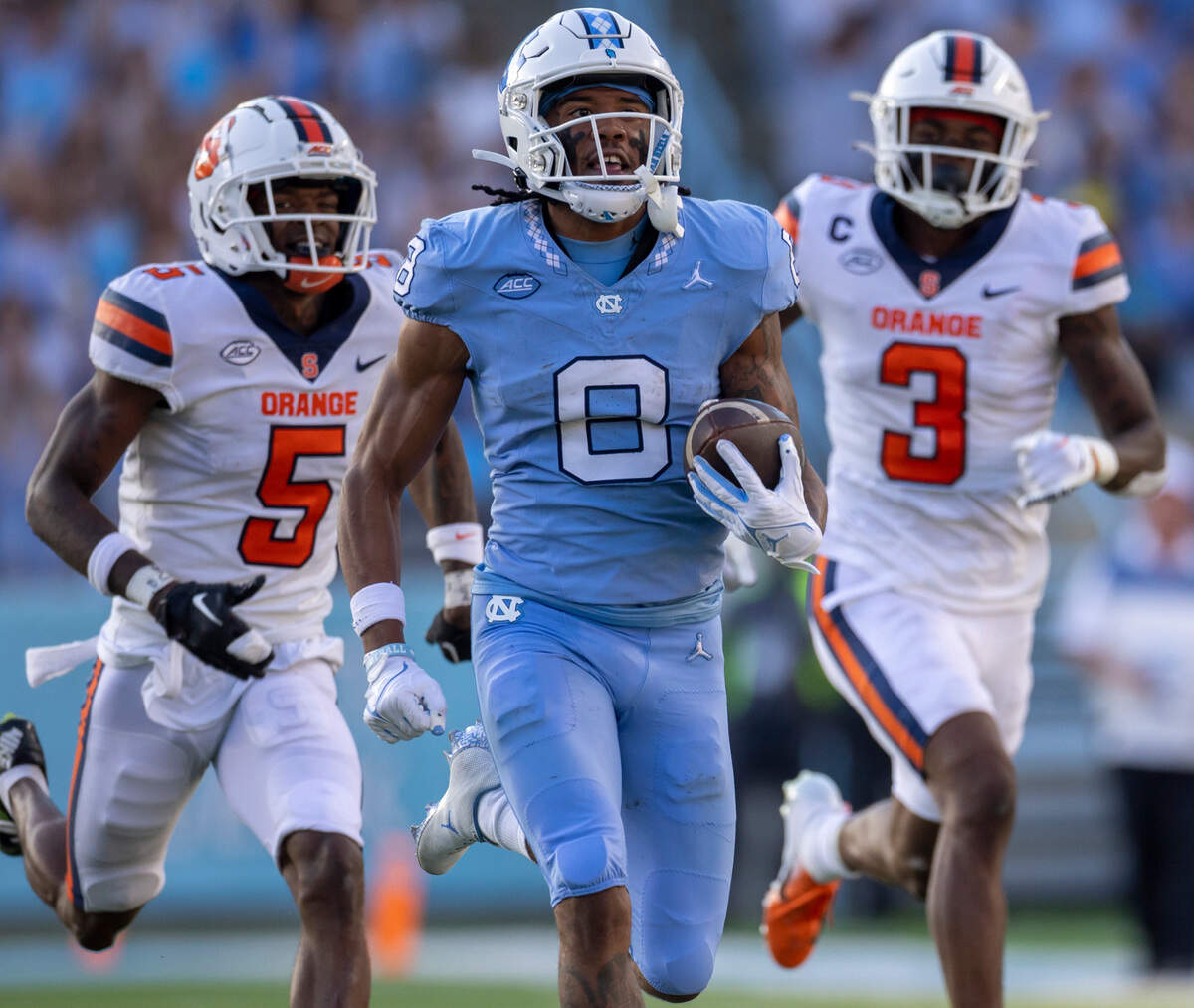 North Carolina’s Kobe Paysour (8) races to the end zone ahead of Syracuse’s Alijah Clark (5) Isaiah Johnson (3) for a 76-yard touchdown on a pass from quarterback Drake Maye to give the Tar Heels’ a 37-7 lead in the third quarter on Saturday, October 7, 2023 at Kenan Stadium in Chapel Hill, N.C.