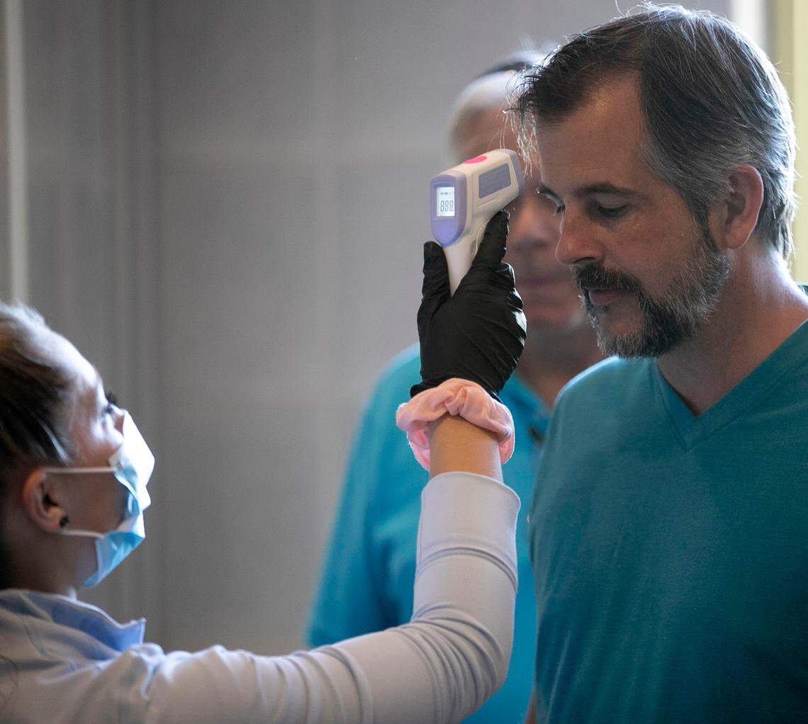 Adam Smith, the husband of ReopenNC co-founder Ashley Smith, has his temperature taken before entering the General Assembly to deliver a petition to North Carolina House Speaker Tim Moore’s office on Friday, June 26, 2020 in Raleigh, N.C.