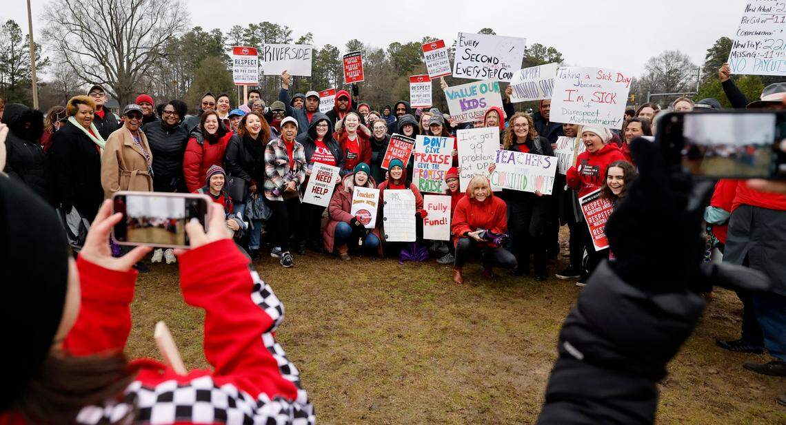 Riverside High School teachers and staff gather for a group photo during a rally at Durham Public Schools Staff Development Center in Durham, N.C., Wednesday, Jan. 31, 2024. Some Durham public schools were closed Wednesday as staff — furious about unresolved salary issues — called in sick to attend protests.