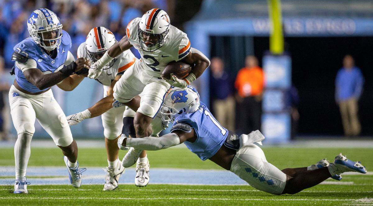 North Carolina’s Antavious Lane (1) works to stop Virginia’s Perris Jones (2) in the second quarter on Saturday, October 21, 2023 at Kenan Stadium in Chapel Hill, N.C.