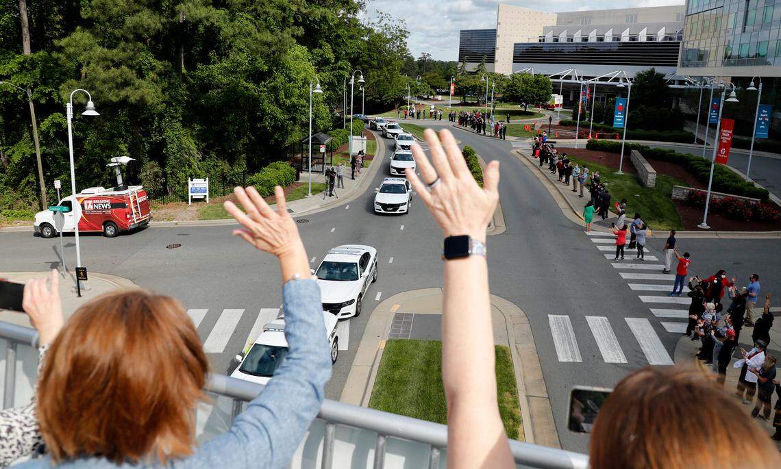 Staff of the Raleigh campus of WakeMed Health and Hospitals watch as a parade of Wake County Sheriff’s Office vehicles parade by Wednesday, April 29, 2020. Members of the Wake County Sheriff’s Office drove around the campus with their lights and sirens on as part of the Badges & Blue Lights caravan to thank local healthcare workers.