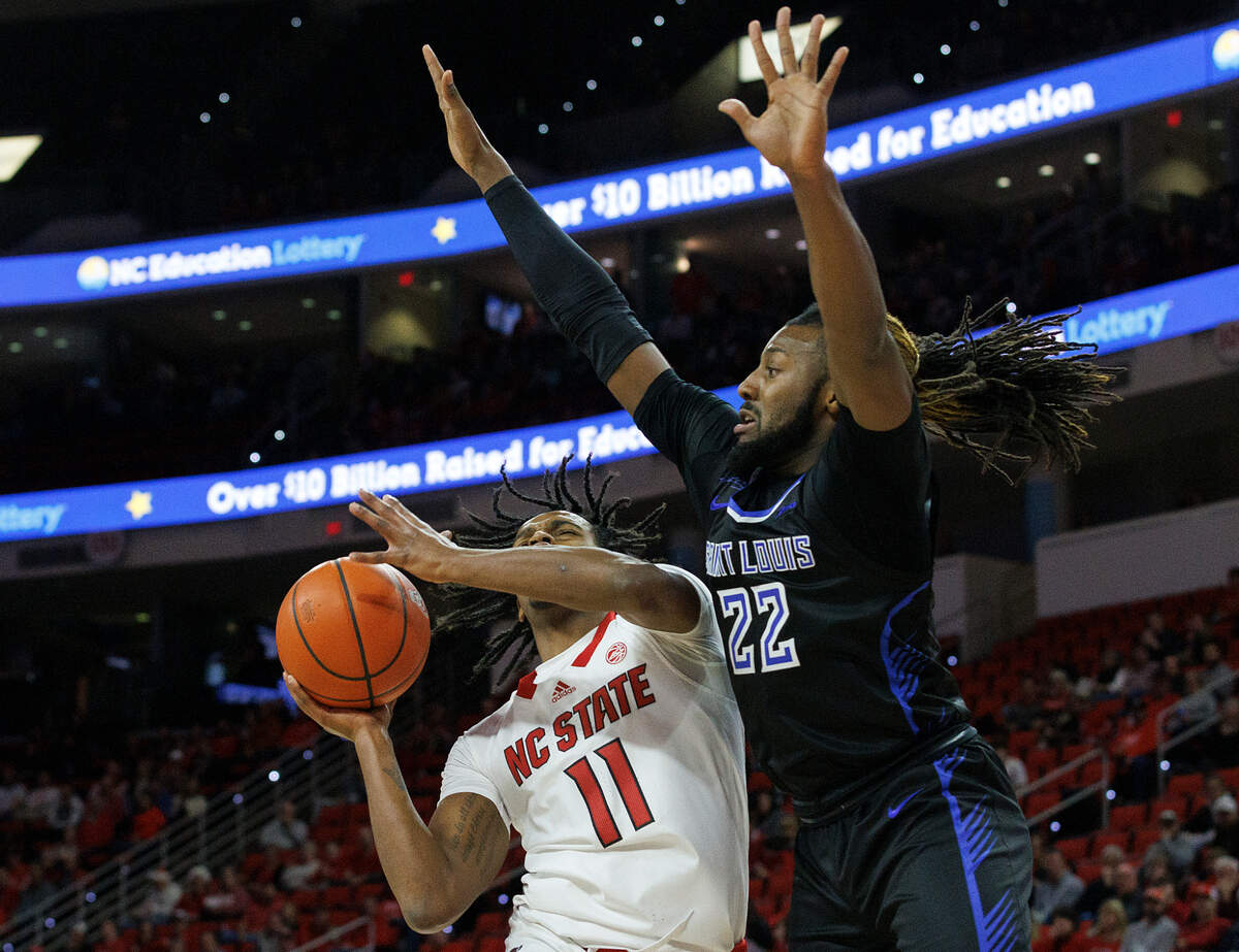 N.C. State’s Dennis Parker Jr. drives against Saint Louis’ Terrence Hargrove Jr. during the first half of the Wolfpack’s 82-70 win on Wednesday, Dec. 20, 2023, at PNC Arena in Raleigh, N.C.