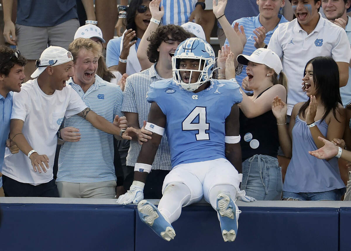 North Carolina linebacker Mikai Gbayor (4) jumps into the stands after scoring on a 61-yard fumble return during the second half of UNC’s 41-6 victory over Richmond at Kenan Stadium in Chapel Hill, N.C., Saturday, Sept. 13, 2025.