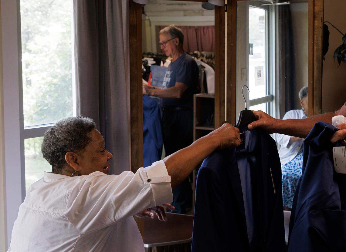Linda Laws, owner of Stitches Tailor Shop, receives a suit for alterations from Tom Grey on Monday, July 15, 2024, in Durham, N.C. After 28 years at its current location on Hillsborough Road, Laws is preparing to relocate the business.