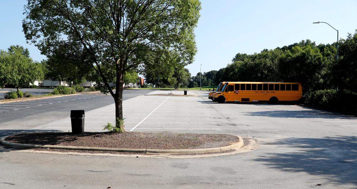 Two school buses are parked in the parking lot at Southeast Raleigh Magnet High School in Raleigh, N.C., in this 2020 file photo. The school has sent students home twice this week due to problems with the air conditioning system.