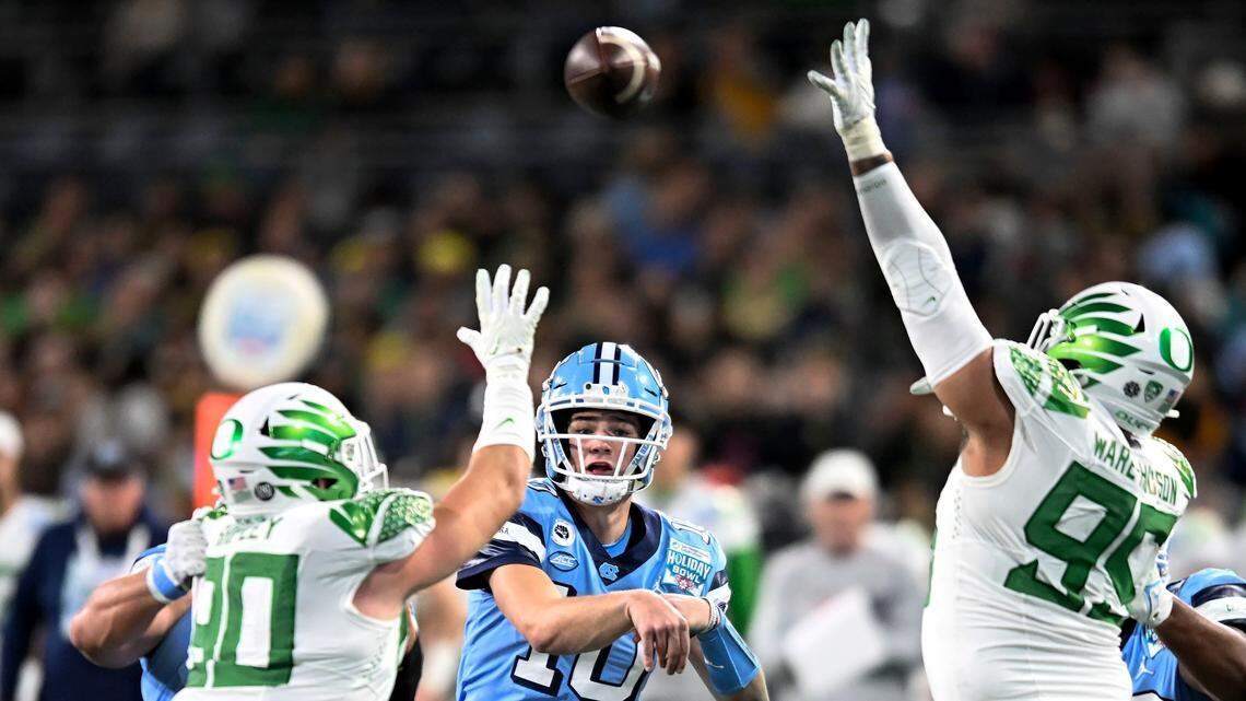 North Carolina quarterback Drake Maye (10) throws over Oregon defensive end Jake Shipley (90), left, and defensive tackle Keyon Ware-Hudson (95) during the first half of the Holiday Bowl NCAA college football game Wednesday, Dec. 28, 2022, in San Diego. (AP Photo/Denis Poroy)
