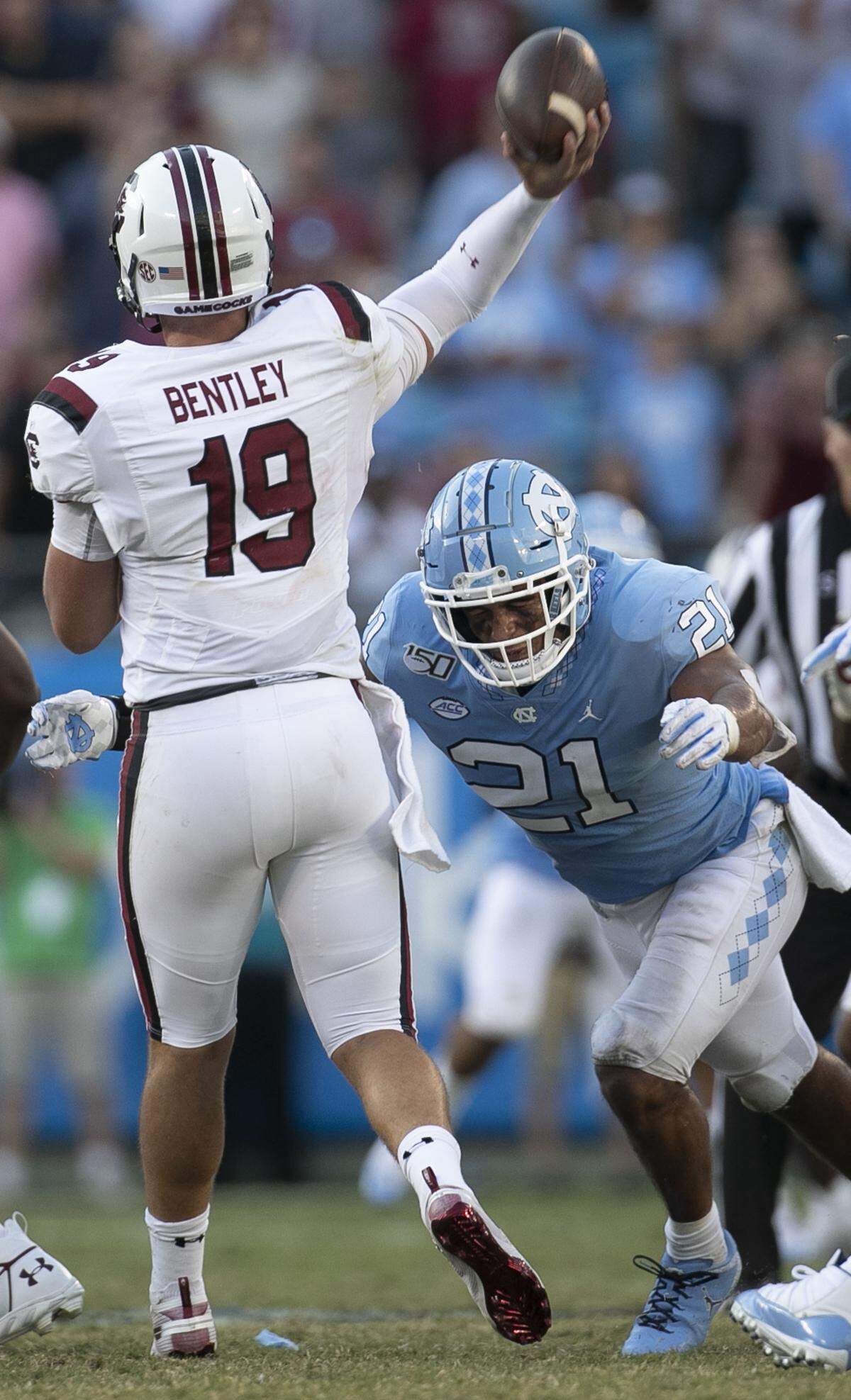 North Carolina linebacker Chazz Surratt (21) pressures South Carolina quarterback Jake Bentley (19), forcing him to throw an interception in the fourth quarter at Bank of America Stadium on Saturday, August 31, 2019 in Charlotte, N.C.