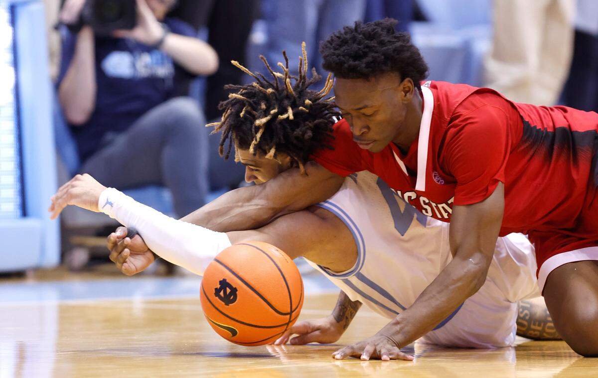 North Carolina’s R.J. Davis (4) dives for the ball with N.C. State’s Jarkel Joiner (1) during the first half of N.C. State’s game against UNC at the Smith Center in Chapel Hill, N.C., Saturday, Jan. 21, 2023.