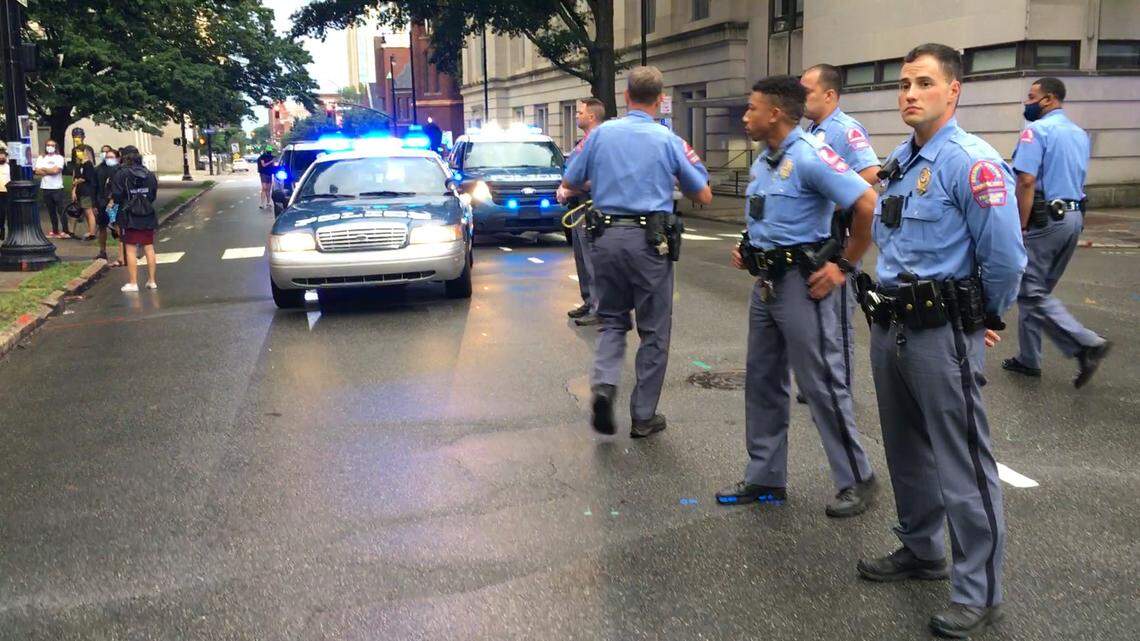 Raleigh Police Dept. officers standby at on E. Morgan Street as protesters surround the Confederate monument on the grounds of the Capitol, Friday evening June 19, 2020.