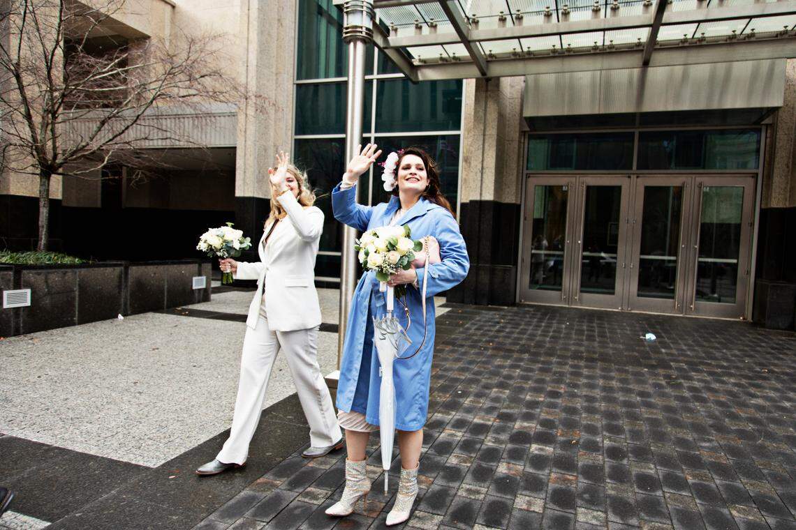 From left, Erica Rogers and Azul Zapata wave at family members after they wed at the Wake County Justice Center in Raleigh on Friday, Feb. 4, 2022. Rogers, who is Canadian, and Zapata, who is Argentinian, were accompanied by their families for the wedding.