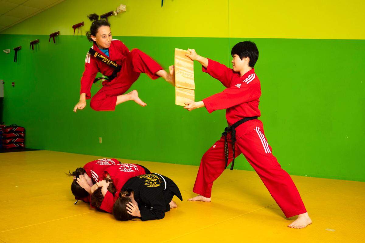 Isaac Campbell completes a jump over Raina White, Keagan White and his brother Jacob Campbell at Master Chang’s Martial Art Studio in Durham, N.C. on June 4, 2024.