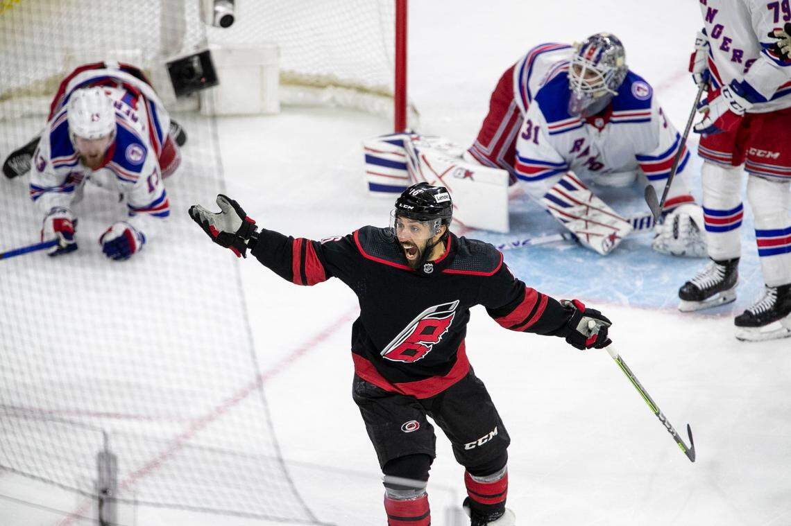 The Carolina Hurricanes’ Vincent Trocheck (16) reacts after New York Rangers’ Alexis Lafreniere (13) crashed into the net with goalie Igor Shesterkin (31) on a scoring attempt during the first period on Thursday, May 26, 2022 during game five of the Stanley Cup second round at PNC Arena in Raleigh, N.C.
