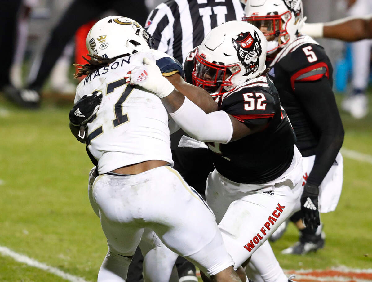N.C. State’s Tyler Baker-Williams (13) and C.J. Clark (52) tackle Georgia Tech running back Jordan Mason (27) during the second half of N.C. State’s 23-13 victory over Georgia Tech at Carter-Finley Stadium in Raleigh, N.C., Saturday, Dec. 5, 2020.