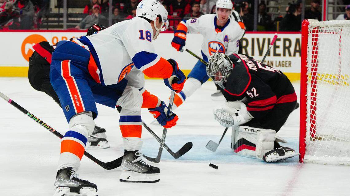 Nov 30, 2023; Raleigh, North Carolina, USA; Carolina Hurricanes goaltender Pyotr Kochetkov (52) stops the scoring attempt by New York Islanders left wing Pierre Engvall (18) during the second period at PNC Arena. Mandatory Credit: James Guillory-USA TODAY Sports
