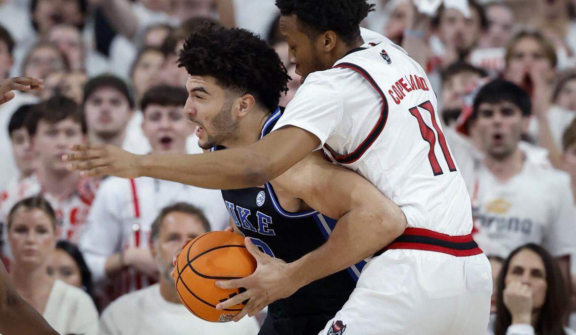 Duke’s Cameron Boozer (12) is defended by NC State's Quadir Copeland (11) during the first half of Duke’s game against N.C. State at the Lenovo Center in Raleigh, N.C., Monday, March 2, 2026.