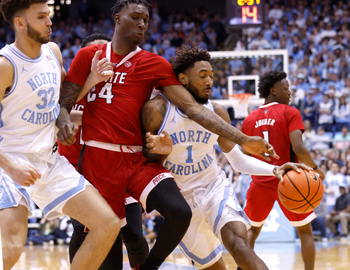 North Carolina’s Leaky Black (1) drives around N.C. State’s Ernest Ross (24) as North Carolina’s Pete Nance (32) sets the pick during the first half of N.C. State’s game against UNC at the Smith Center in Chapel Hill, N.C., Saturday, Jan. 21, 2023.