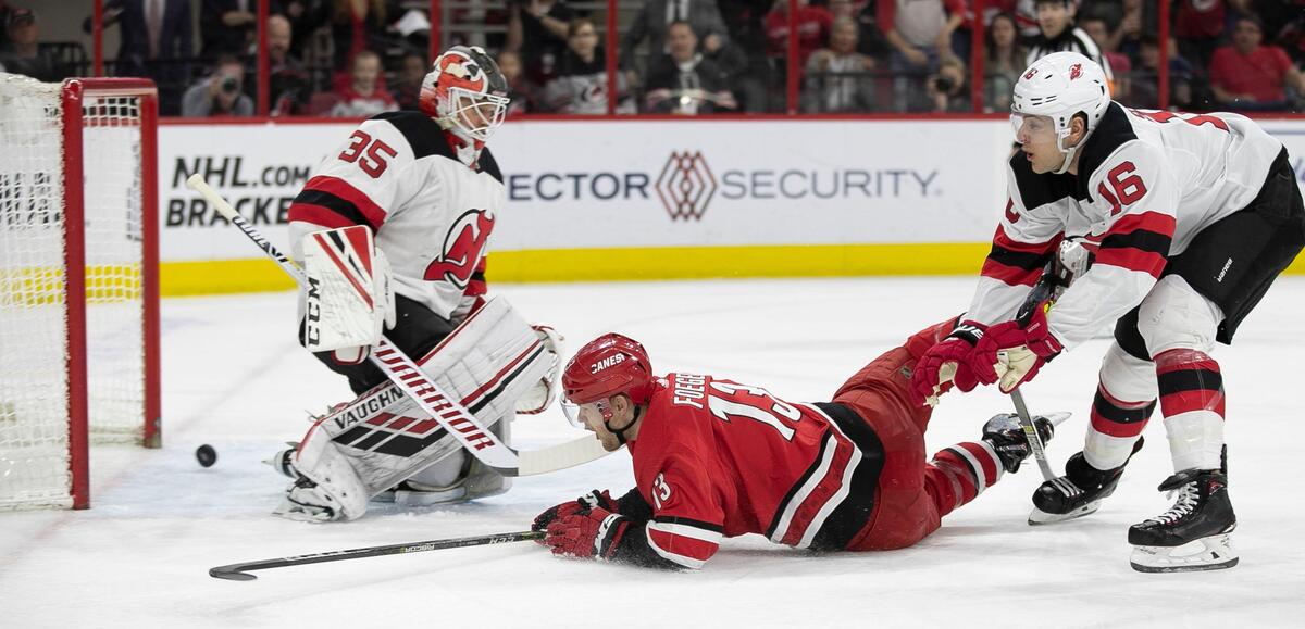 Carolina Hurricanes’ Warren Foegele (13) scores on New Jersey goalie Cory Schneider (35) during the first period to tie the Devils 1-1 on Thursday, April 4, 2019 at the PNC Arena in Raleigh, N.C.