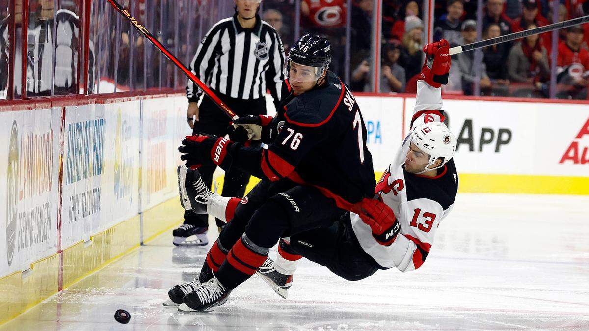 New Jersey Devils’ Nico Hischier (13) collides with Carolina Hurricanes’ Brady Skjei (76) during the first period of an NHL hockey game in Raleigh, N.C., Tuesday, Jan. 10, 2023.