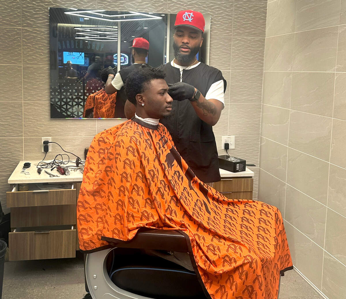 BJ Williams cuts the hair of North Carolina defensive back Marcus Allen on Monday, October 28, 2024.