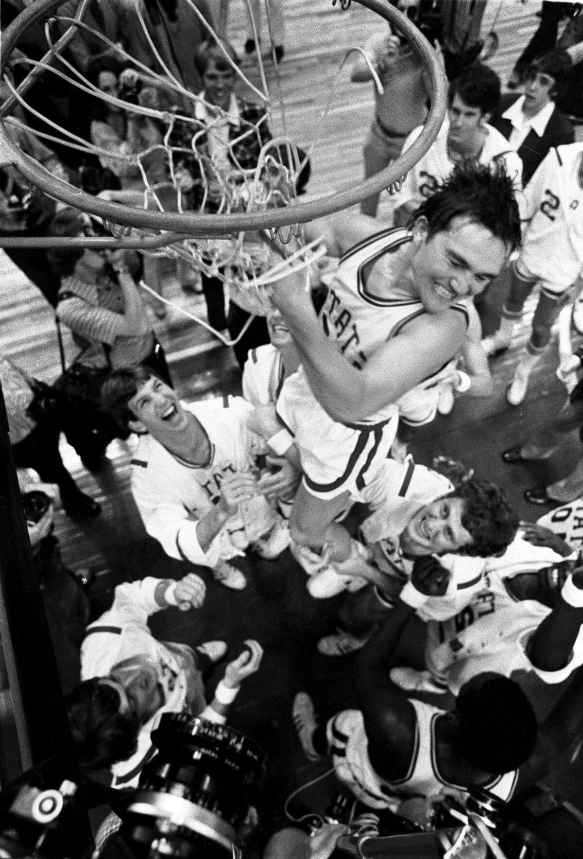 NC State point guard Monte Towe cuts down the nets after the Wolfpack defeated Maryland to win the ACC Tournament in Greensboro, NC in 1974.