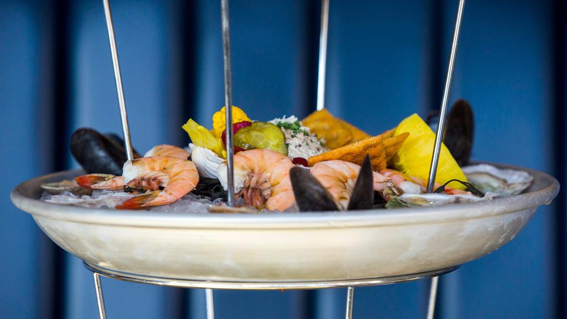 The USS Nimitz towers above the table with its three tiers of lobster, oysters, shrimp, clams, mussels, crab claws, king crab, ceviche, tartare and smoked fish dip at Saint James Seafood on Thursday, Mar. 14, 2018, in Durham, NC.