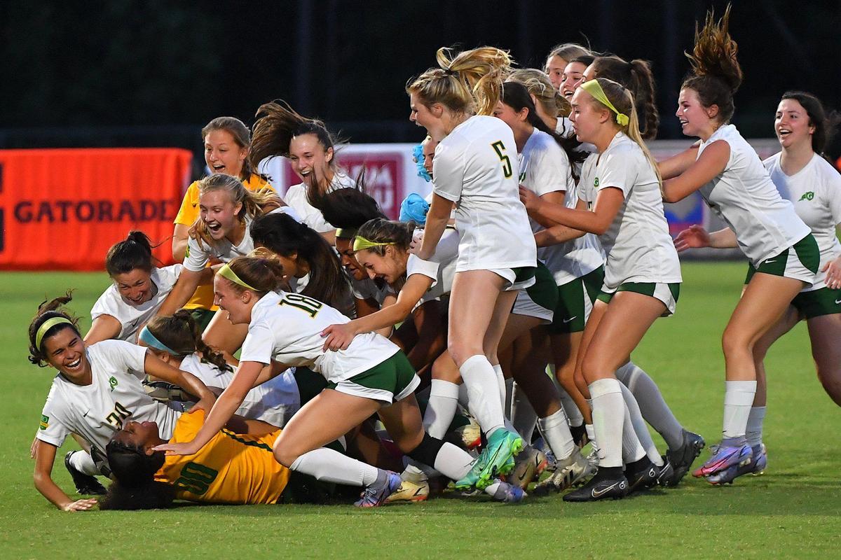 Cardinal Gibbons goalkeeper Rhian Lawrence (0) is rushed by teammates after their victory over Ardery Kell in penalty kicks. The Cardinal Gibbons Crusaders and the Ardery Kell Knights met in the NCHSAA Women’s 4A Soccer Championships in Cary, N.C. on June 4, 2022.