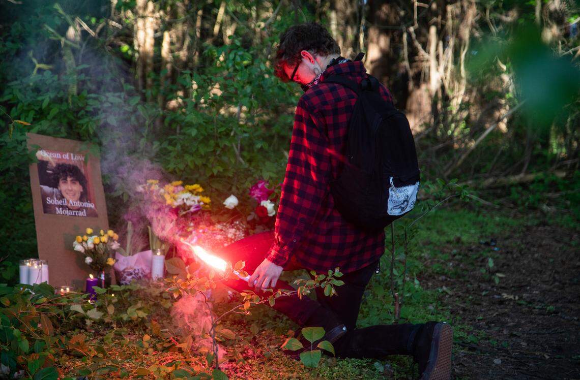 A mourner burns a flare at a makeshift memorial following a vigil for Soheil Antonio Mojarrad, 30, of Raleigh near a shopping center off New Bern Avenue in Raleigh Tuesday, April 23, 2019. Mojarrad was killed in an officer-involved shooting Saturday.