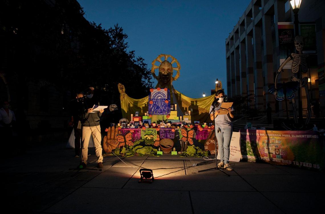 Ron Garc’a Fogarty, left, and Johana Bravo, address the the crowd in both English and Spanish in front of an altar assembled to honor the lives of farmworkers and poultry processing workers who have died from COVID-19, during a protest to call on the NC Department of Labor to enforce safety standards and protect workers, on Thursday, Nov. 5, 2020, in Raleigh, N.C.