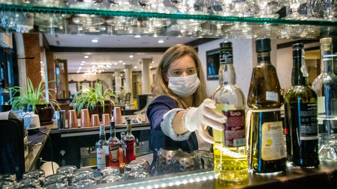 Annabel Butler, restaurant manager and sommelier at Il Palio, restocks liquor at the restaurant’s bar ahead of Gov. Roy Cooper’s Phase Two of reopening during the coronavirus pandemic, on Thursday, May 21, 2020, in Chapel Hill, N.C.