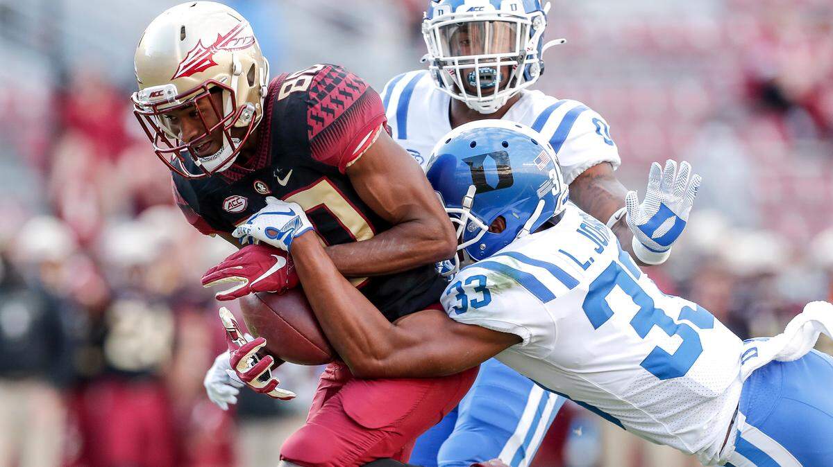 Wide Receiver Ontaria Wilson #80 of the Florida State Seminoles makes a catch over safety Marquis Waters #0 and cornerback Leonard Johnson #33 of the Duke Blue Devils during the game at Doak Campbell Stadium on Bobby Bowden Field on December 12, 2020 in Tallahassee, Florida.