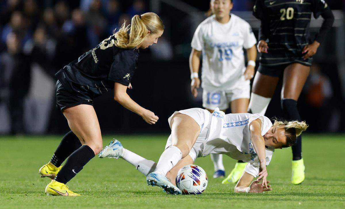 Wake Forest’s Emily Morris (13) trips North Carolina’s Evelyn Shores (2) during the first half of UNC’s game against Wake Forest in the finals of the 2024 Women’s College Cup at WakeMed Soccer Park in Cary, N.C., Monday, Dec. 9, 2024.