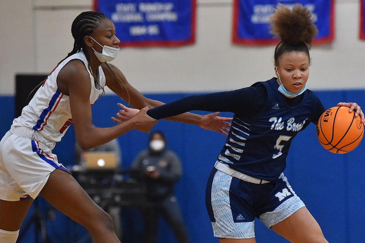 Wake forest’s Amina Miles (22) fouls Millbrook’s Reychel Douglas (5) late in the second half. The Wake Forest Cougars and the Millbrook Wildcats met in a basketball game in Wake Forest, N.C. on February 8, 2022.