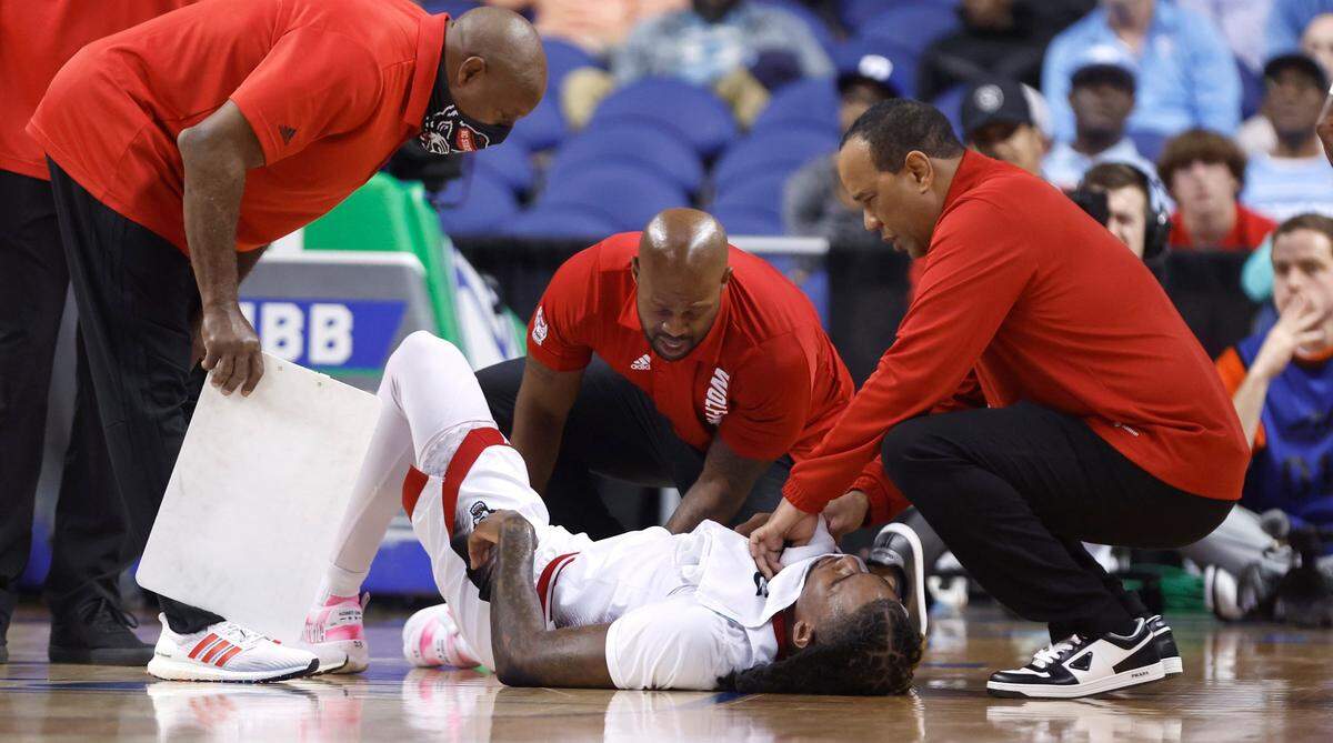 N.C. State head coach Kevin Keatts wipes the sweat from Greg Gantt (23) after he was injured during the first half of N.C. State’s game against Virginia Tech in the second round of the ACC Men’s Basketball Tournament in Greensboro, N.C., Wednesday, March 8, 2023.