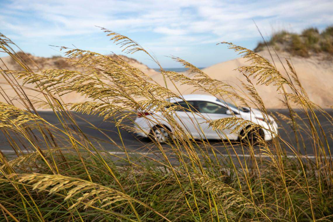 Traffic moves along NC 12 adjacent to dunes, where less than 500 feet separate the Atlantic Ocean and the Pamlico Sound, in one of the hots spots the NC 12 Task Force is studying to find solutions to erosion and flooding on Tuesday, July 13, 2021 in Hatteras, N.C.