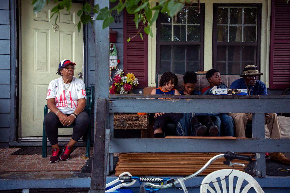 Ivory Faulk watches the street from her front porch as three of her 59 great-grandchildren and a neighbor play games on their phones, on Thursday, Aug. 15, 2019, in Wilmington, NC. For 37 years, Faulk has lived in this home which is now located in NC Senate District 8, represented by Republican Sen. Bill Rabon along with large areas of rural Bladen, Pender and Brunswick counties. The rest of New Hanover County is located in District 9, represented by Democratic Sen. Harper Peterson.