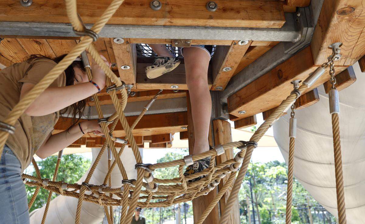 Participants enjoy one of the four multi-story climbing towers at Gipson Play Plaza at Dix Park during a preview day Saturday.