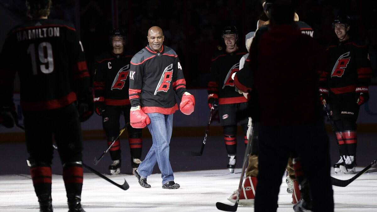 Former professional boxer Evander Holyfield joins the Carolina Hurricanes’ on-ice celebration after the Hurricanes defeated the St. Louis Blues 5-2 on Friday.