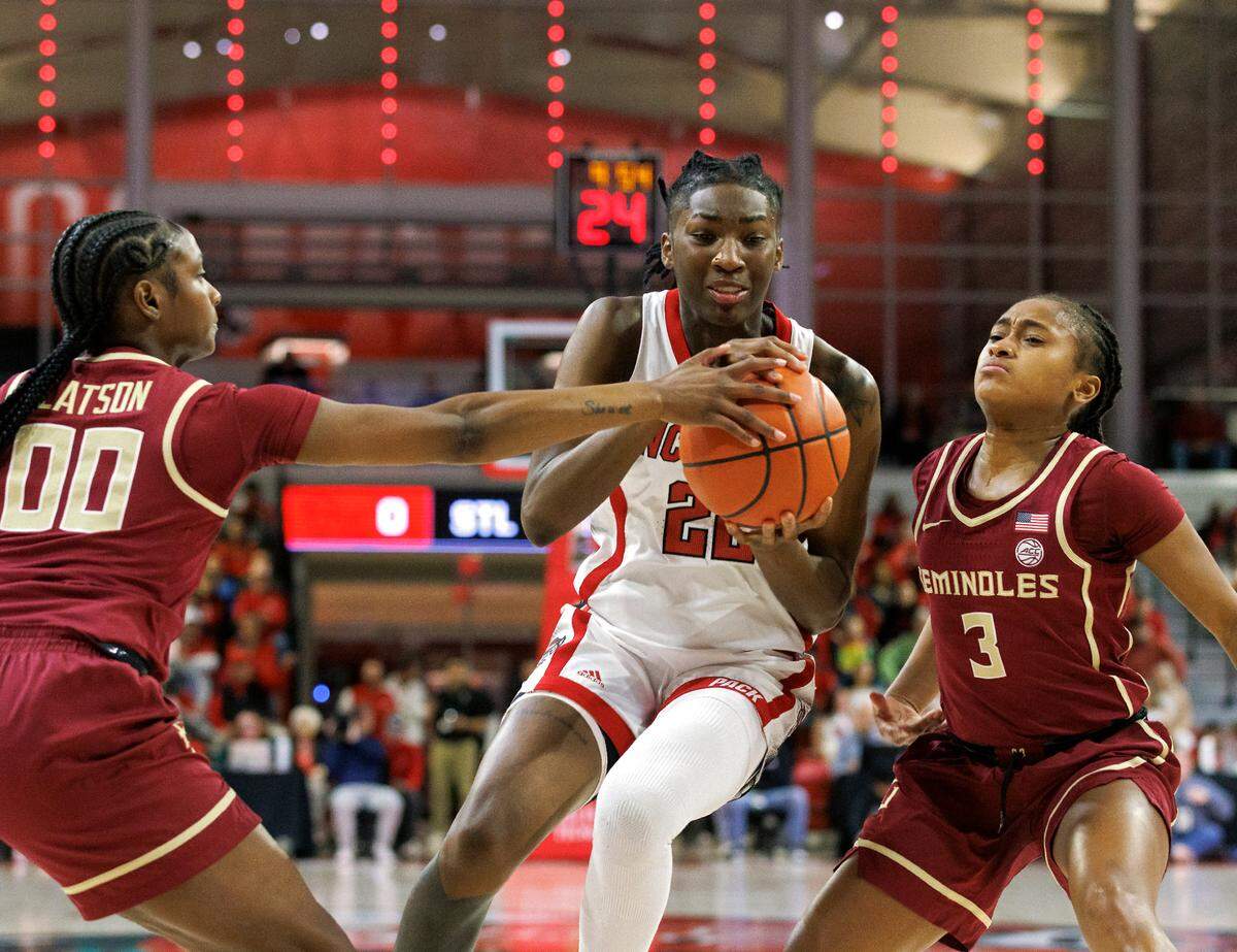 N.C. State’s Saniya Rivers splits the defense of Florida State’s Ta’Niya Latson and O’Mariah Gordon during the first half of the Wolfpack’s game on Thursday, Jan. 4, 2023, at Reynolds Coliseum in Raleigh, N.C.