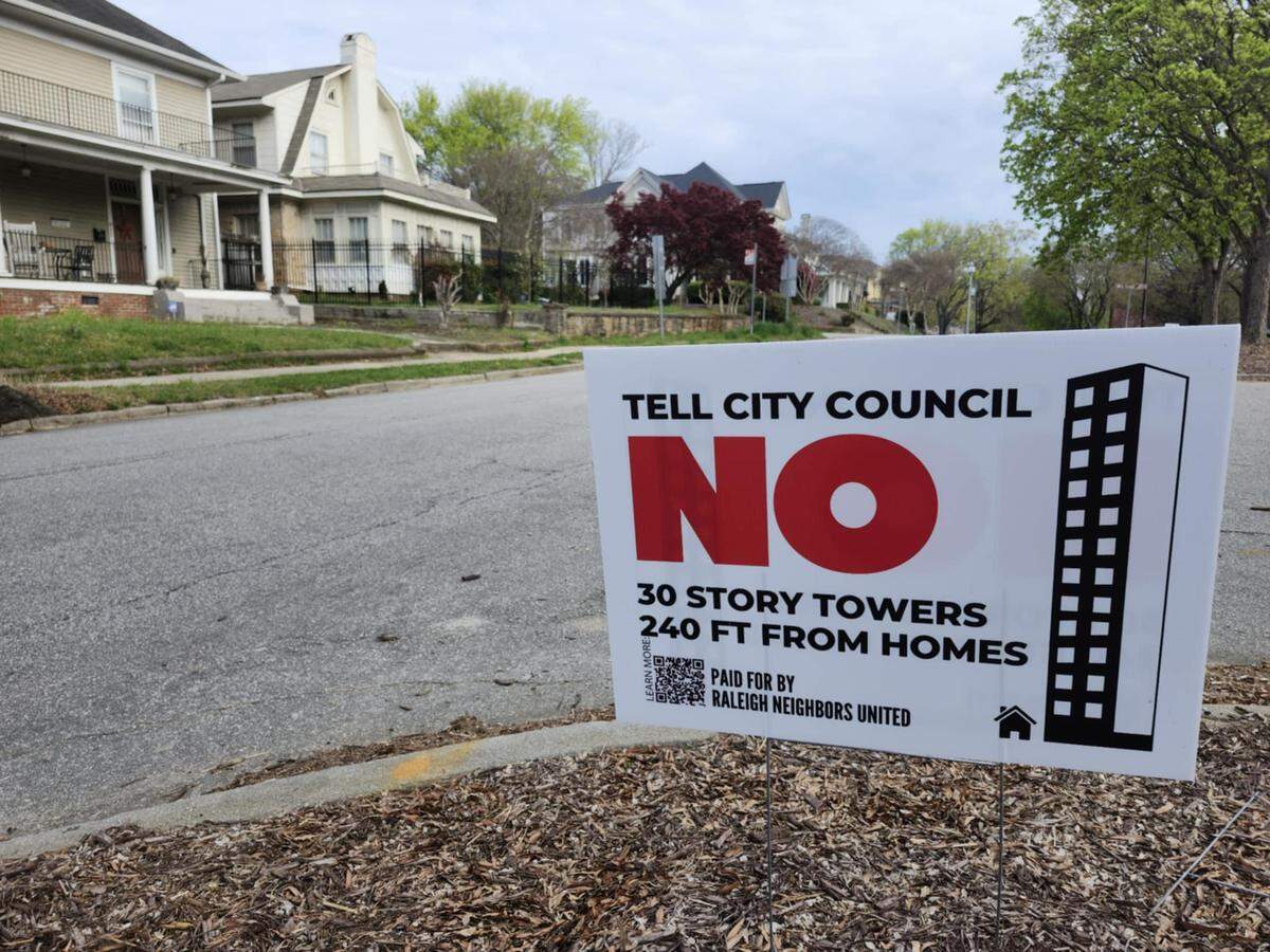 Signs dot streets near the Glenwood-Brooklyn Historic Neighborhood against a proposed rezoning at the intersection of Peace and West streets.