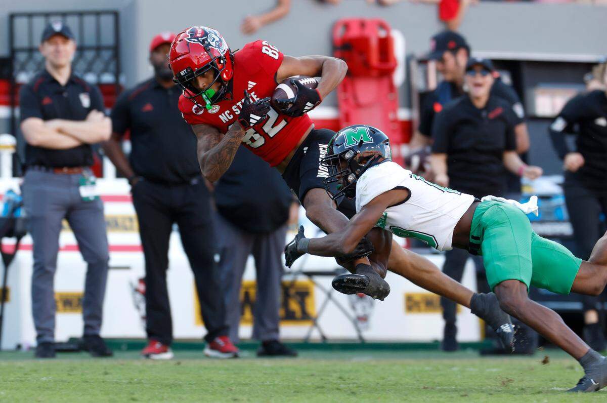 N.C. State wide receiver Terrell Timmons Jr. (82) makes a 47-yard reception as Marshall defensive back Dyoni Hill (19) defends during the second half of N.C. State’s 48-41 victory over Marshall at Carter-Finley Stadium in Raleigh, N.C., Saturday, Oct. 7, 2023.
