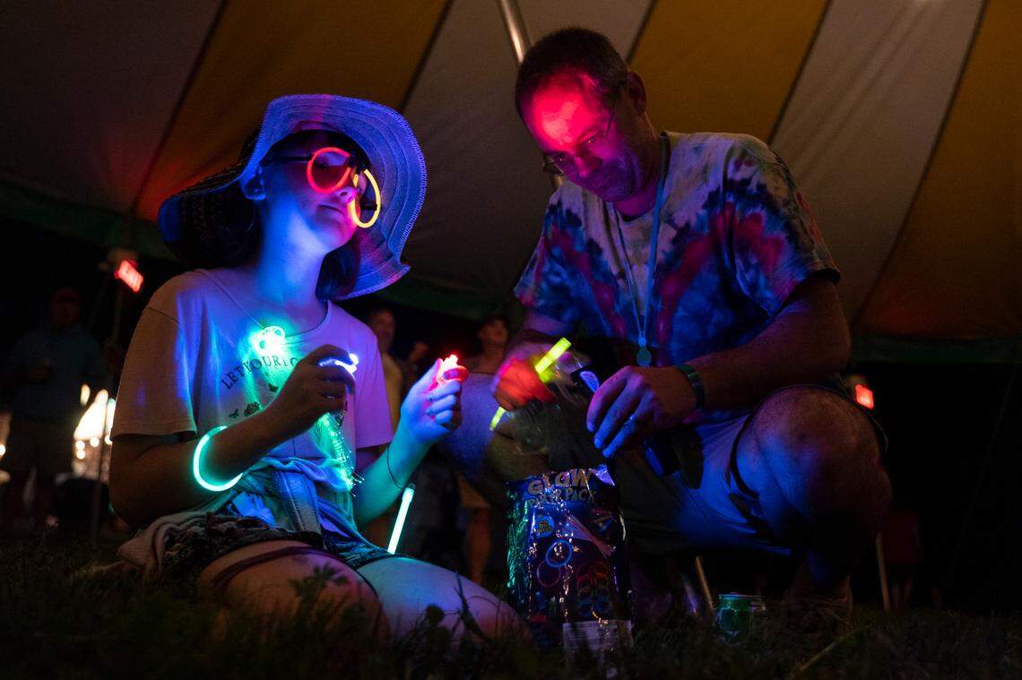 Sophie Shakelford, accompanied by her father Aaron, sports neon glow stick glasses at the 18th annual Shakori Hills GrassRoots Festival in Pittsboro, N.C. on May 5, 2022. It returns Oct. 6-9.
